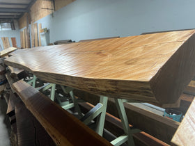 A live edge style fireplace mantel, made from birch wood, displayed on a rack.