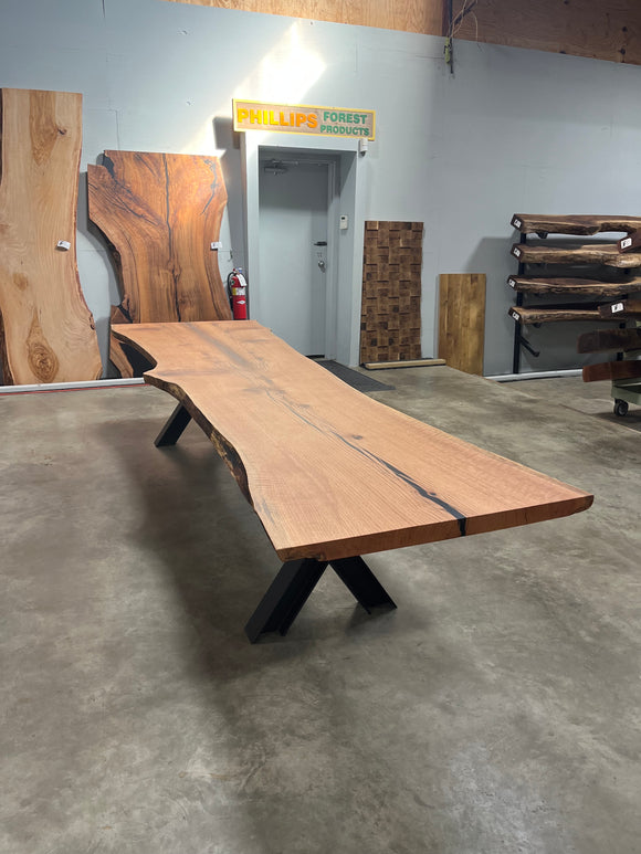 Live edge red oak wood slab with rich grain patterns, natural knots, and kiln-dried hardwood surface for custom furniture or table making.