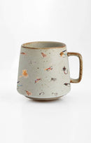 A beige stoneware mug with colorful lifelike fly fishing illustrations around the exterior.