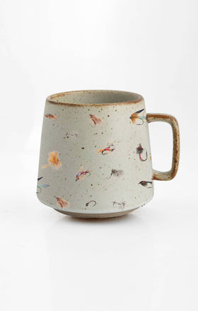 A beige stoneware mug with colorful lifelike fly fishing illustrations around the exterior.
