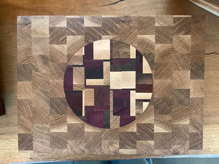 Wooden cutting board with geometric pattern on a wooden surface