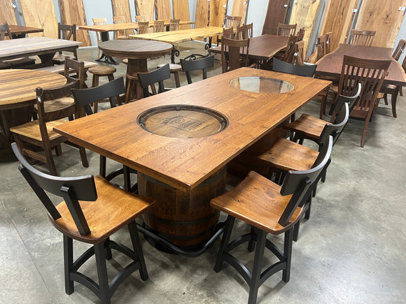 Wooden dining table with hot pot feature surrounded by chairs in a showroom setting.