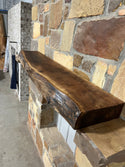 Beautiful, rustic, circle sawn, live edge walnut mantel sitting on corbels of a stone fireplace