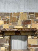 Live edge view of a beautiful walnut mantel sitting on stone corbels of a fireplace