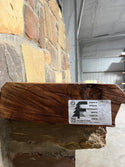 End of live edge cherry mantel on stone corbel with the forest store label