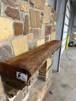 Live edge, circle sawn cherry mantel on stone corbels