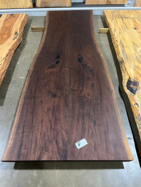 Live edge walnut wood slab with rich dark grain and natural edges.
