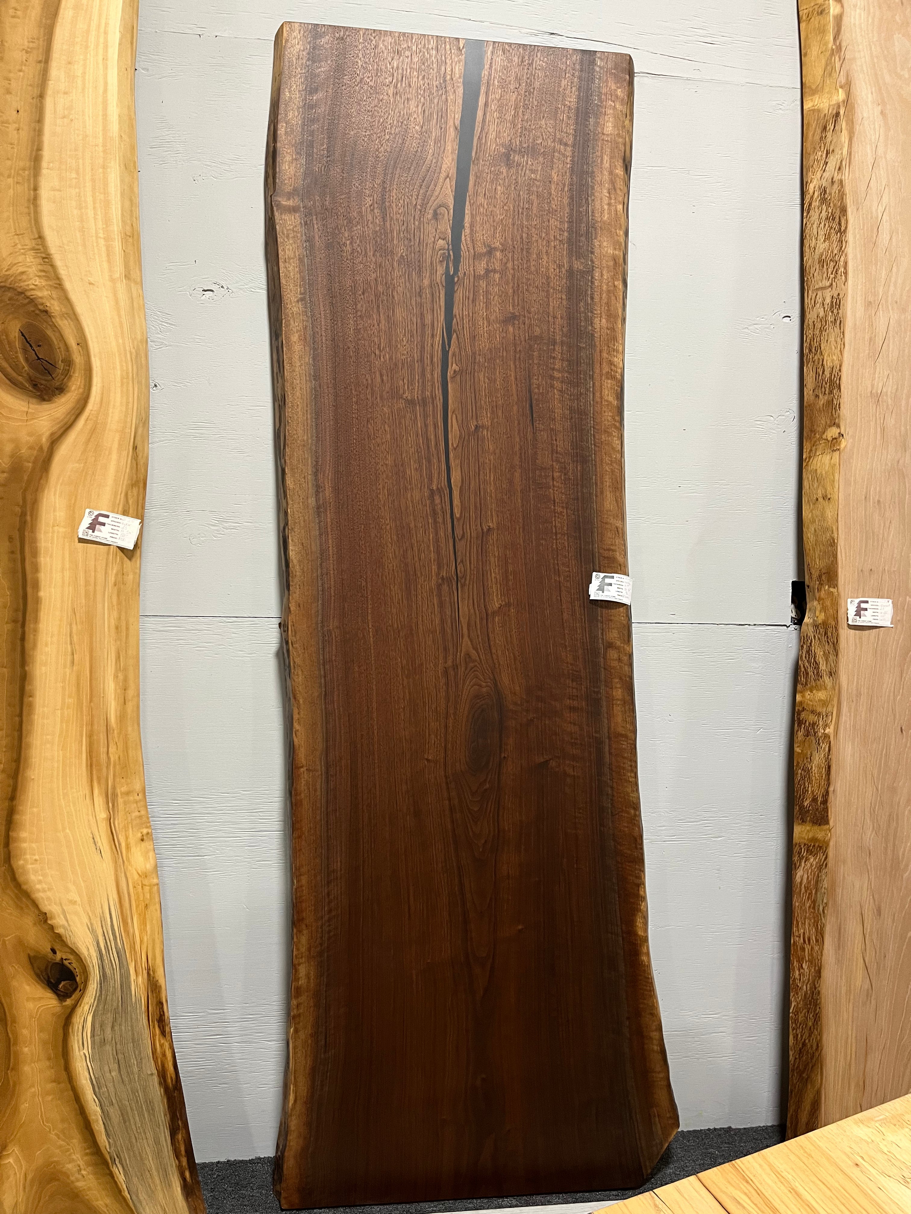 Live edge walnut wood slab with rich dark grain and natural edges.
