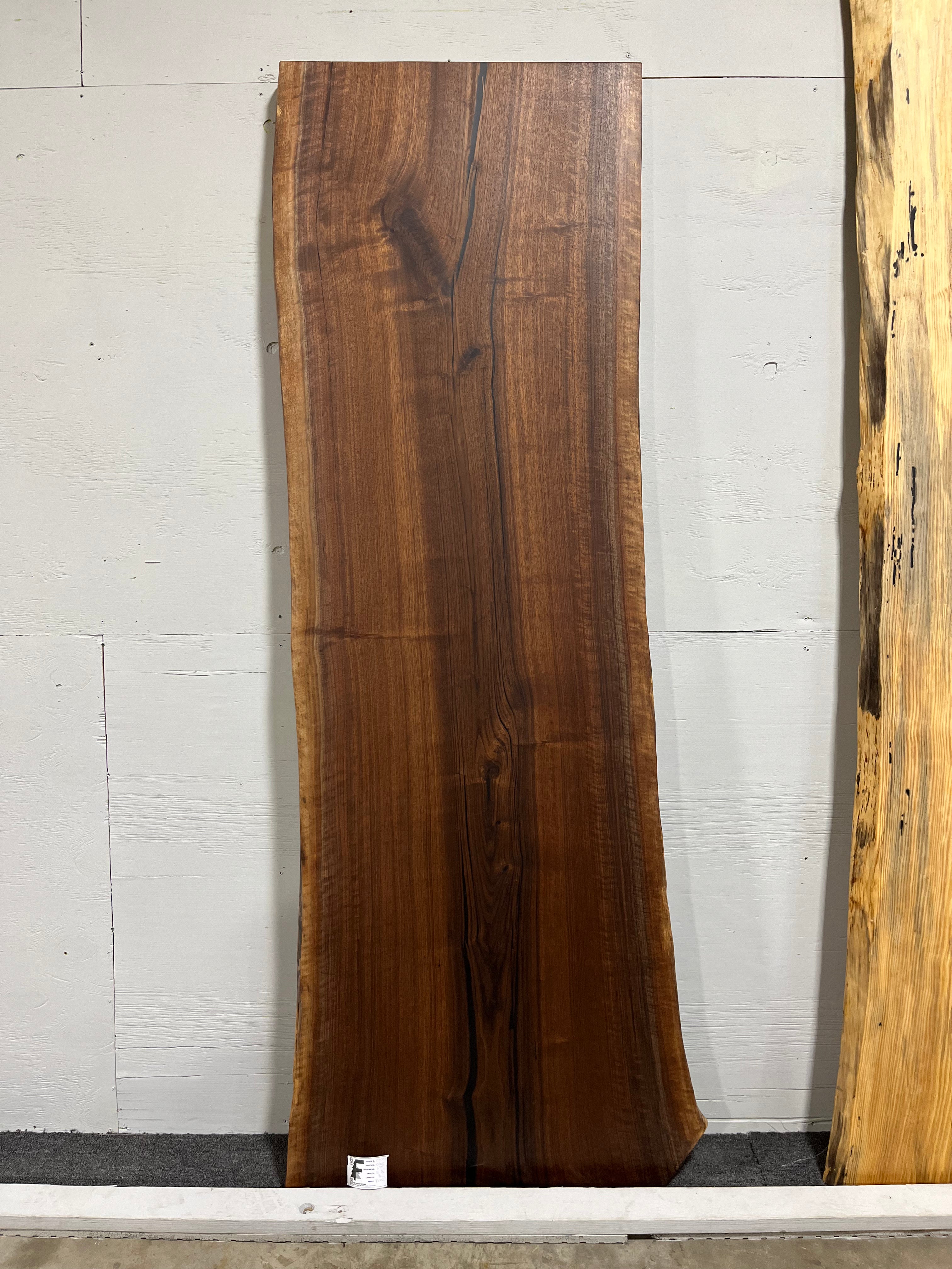 Live edge walnut wood slab with rich dark grain and natural edges.
