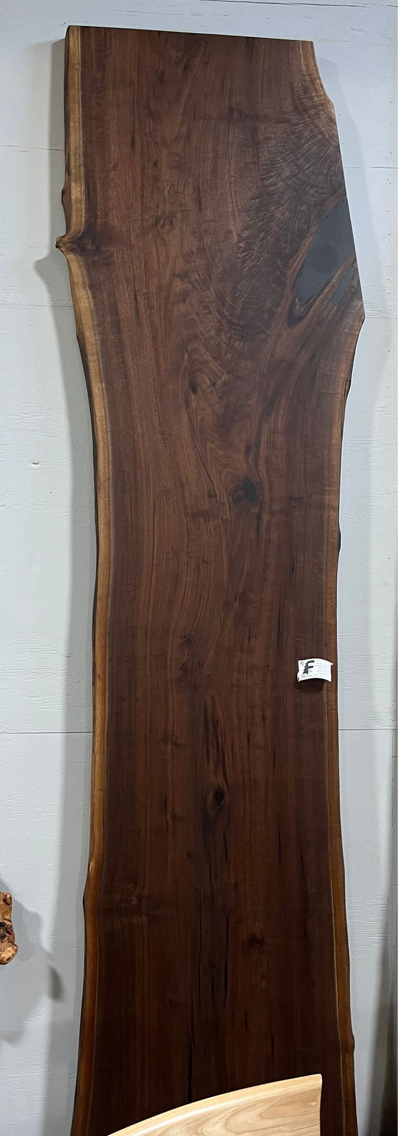 Live edge walnut wood slab with rich dark grain and natural edges.
