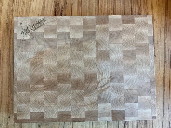 Wooden cutting board with a checkered pattern on a wooden surface