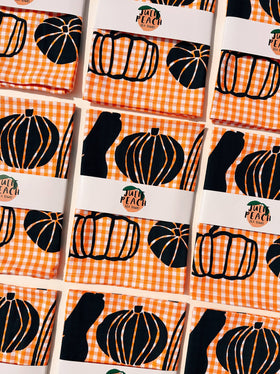 Pumpkin-themed product packaging with a checkered pattern on a grid background