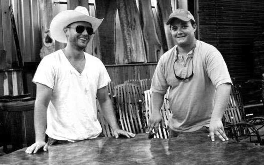 allen and cole phillips standing at a burl table at phillips forest products.