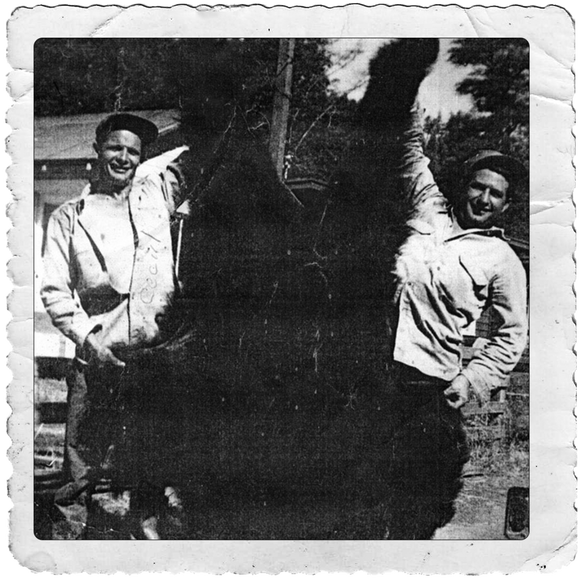 two men standing beside a bear they killed while bear hunting in northern california