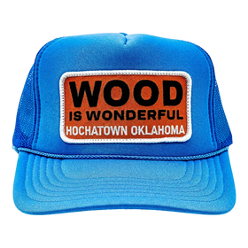 A blue trucker hat with a Wood is Wonderful Hochatown Oklahoma patch