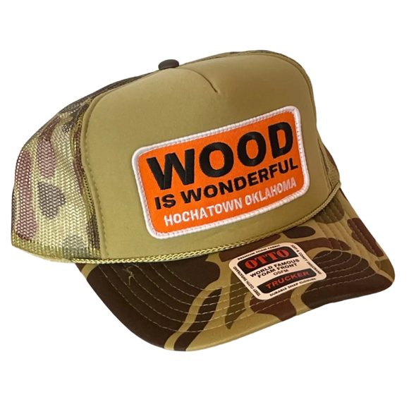 A camo trucker hat with a Wood is Wonderful Hochatown Oklahoma patch