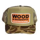 A camo trucker hat with a Wood is Wonderful Hochatown Oklahoma patch