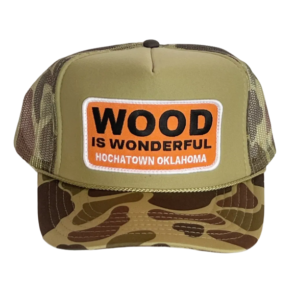 A camo trucker hat with a Wood is Wonderful Hochatown Oklahoma patch