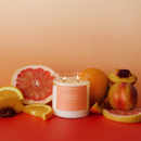 Candle labeled 'Peach & Mectar' surrounded by fruit on a gradient background