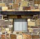 A burnt solid oak wood beam mantel mounted on a stone fireplace