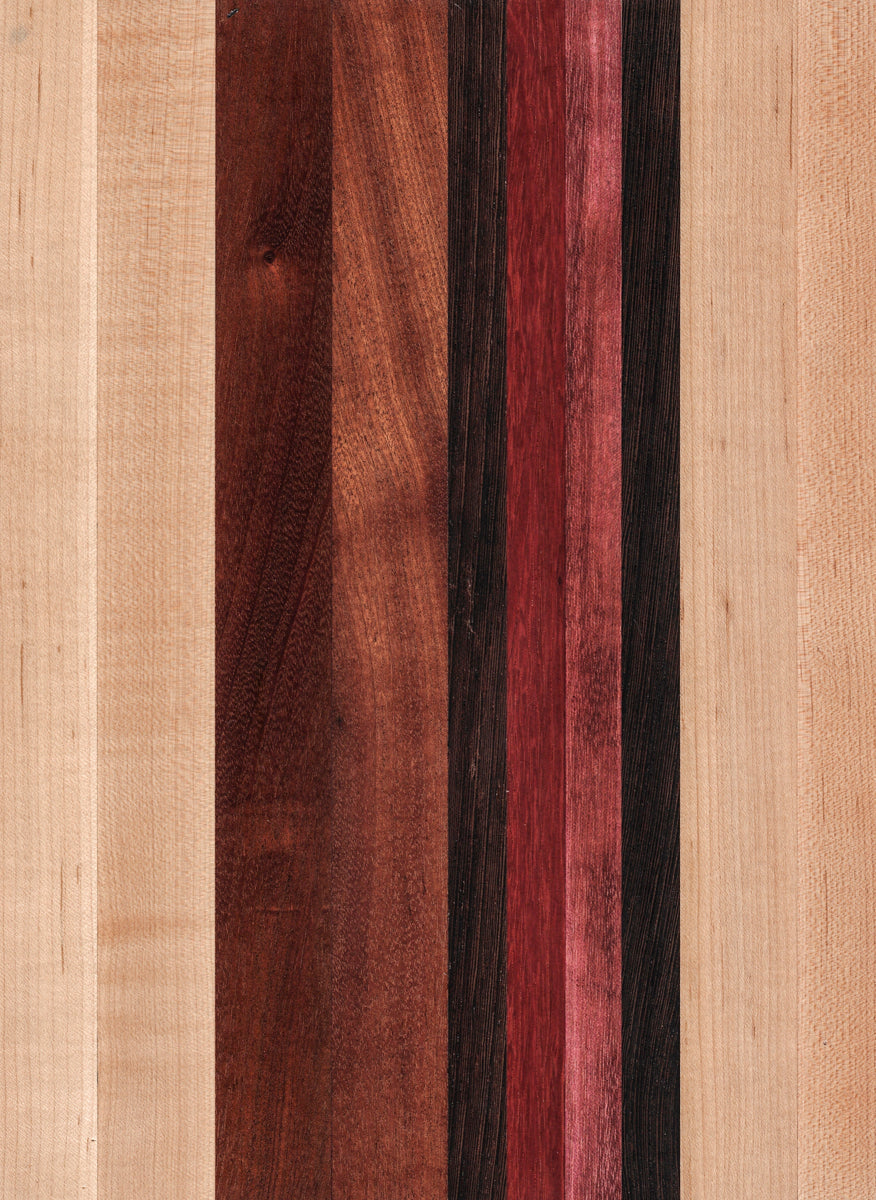 A striped cutting board made of various wood shades, including light beige and darker brown, with a smooth surface.