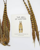 Book titled 'The ABCs of Hunting' with feathers on a white background