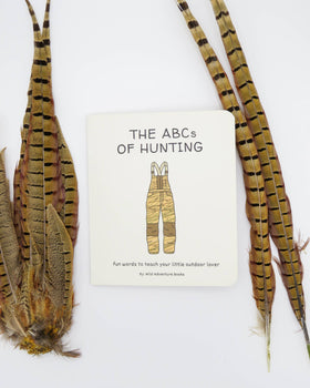 Book titled 'The ABCs of Hunting' with feathers on a white background