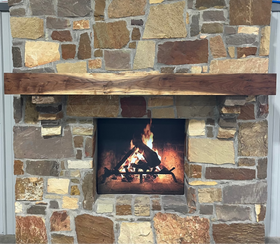 A beam style fireplace mantel, made from walnut wood, displayed on a rack.