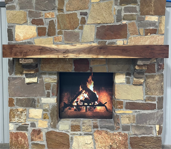 A beam style fireplace mantel, made from walnut wood, displayed on a rack.