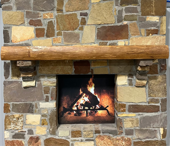A live edge style fireplace mantel, made from ash wood, mounted on a stone wall.