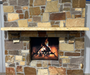 A live edge style fireplace mantel, made from ash wood, mounted on a stone wall.