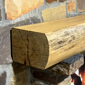 A live edge style fireplace mantel, made from birch wood, mounted on a stone wall.