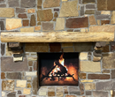 A live edge style fireplace mantel, made from birch wood, mounted on a stone wall.