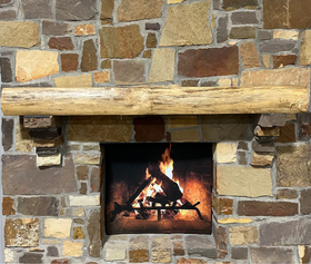 A live edge style fireplace mantel, made from birch wood, mounted on a stone wall.