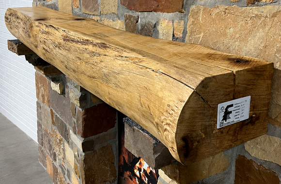 A live edge style fireplace mantel, made from birch wood, mounted on a stone wall.