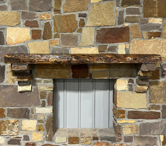 A live edge style fireplace mantel, made from bois d'arc wood, mounted on a stone wall.