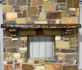 Solid live edge bois d'arc fireplace mantel mounted on a stone wall.

