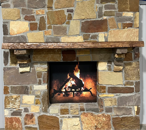 A live edge style fireplace mantel, made from cherry wood, mounted on a stone wall.