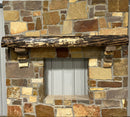 A live edge style fireplace mantel, made from walnut wood, mounted to a rock wall.