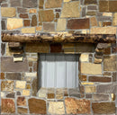 A live edge style fireplace mantel, made from walnut wood, mounted to a rock wall.