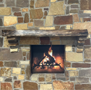 A live edge style fireplace mantel, made from walnut wood, mounted to a rock wall.
