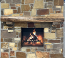A live edge style fireplace mantel, made from walnut wood, mounted to a rock wall.