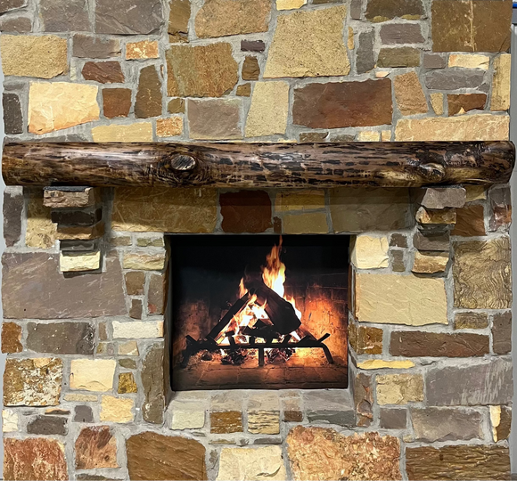 A live edge style fireplace mantel, made from walnut wood, mounted to a rock wall.