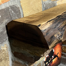 A live edge style fireplace mantel, made from walnut wood, mounted to a rock wall.