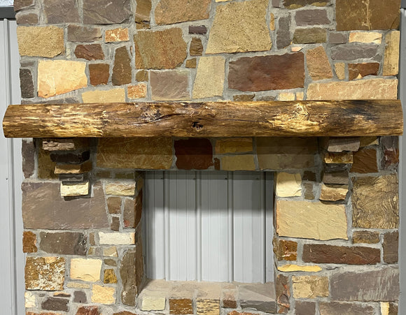 A live edge style fireplace mantel, made from white oak wood, mounted on a stone wall.