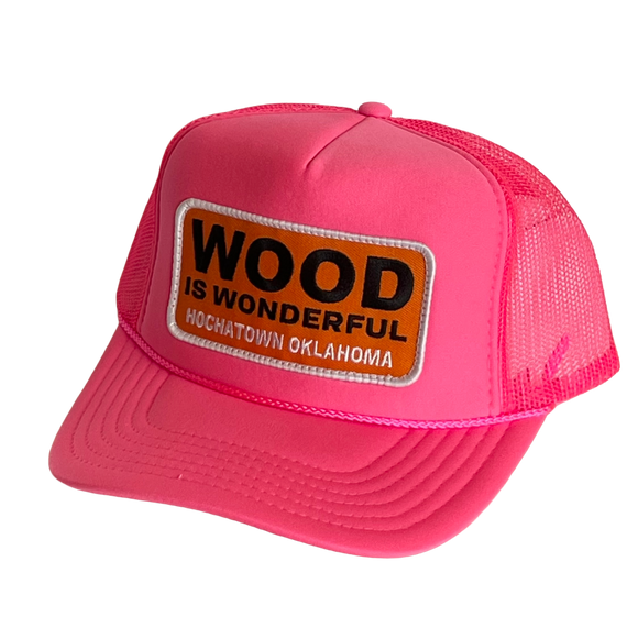 A hot pink trucker hat with a Wood is Wonderful Hochatown Oklahoma patch