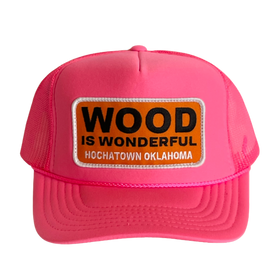 A hot pink trucker hat with a Wood is Wonderful Hochatown Oklahoma patch
