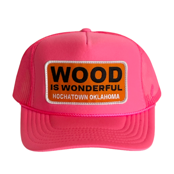 A hot pink trucker hat with a Wood is Wonderful Hochatown Oklahoma patch