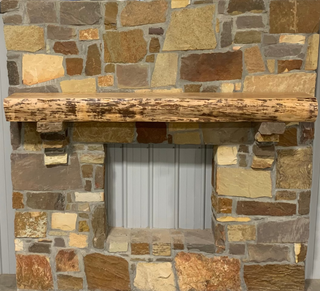 Solid live edge birch fireplace mantel mounted on a stone wall