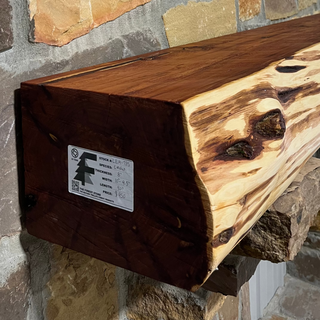 Solid live edge cedar fireplace mantel mounted on a stone wall.